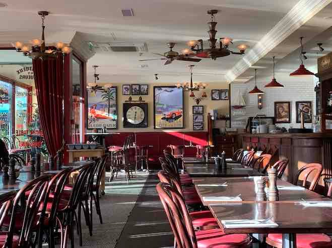 a photo of the interior of Cafe Rouge St Kathryn Docks with french-styled artwork on display