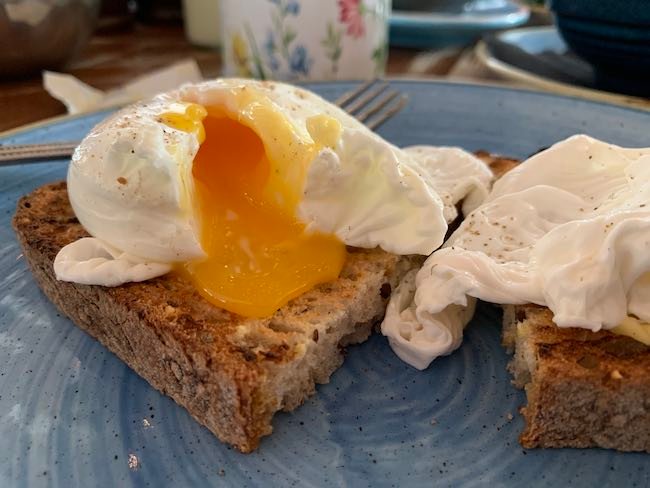 a photo of the poached eggs from Megans Clapham Common. The egg has been cut open and the yolk is running onto the toast