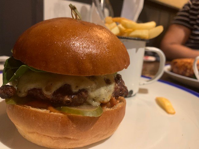 a low-down close-up photo side-on on the burger showing the melted cheese from The Abbeville Clapham