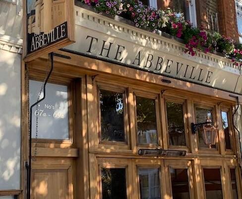 a photo of the outside of The Abbeville in Clapham including the signs