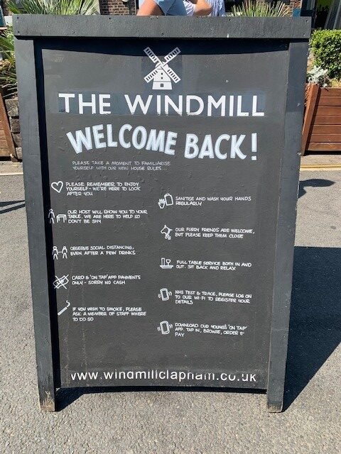 An 'A-Board' outside The Windmill Clapham Common explaining their new requirements during the pandemic